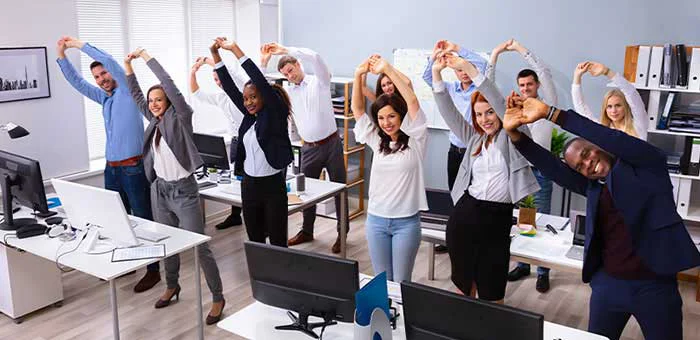 office team stretching together under guidance of Ontario chiropractor