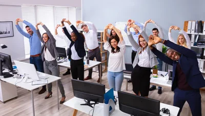 office team stretching together under guidance of Ontario chiropractor